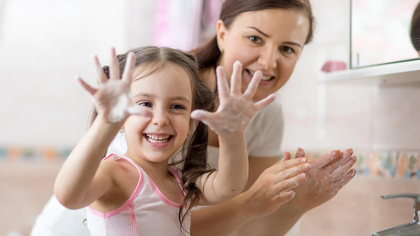 Mutter mit Tochter beim Händewaschen