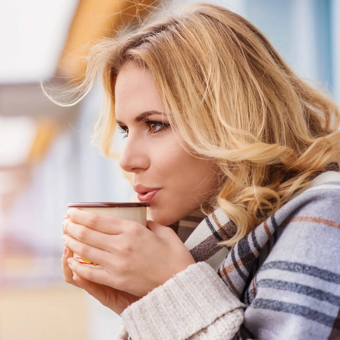 junge Frau trinkt einen heißen Tee am Strand