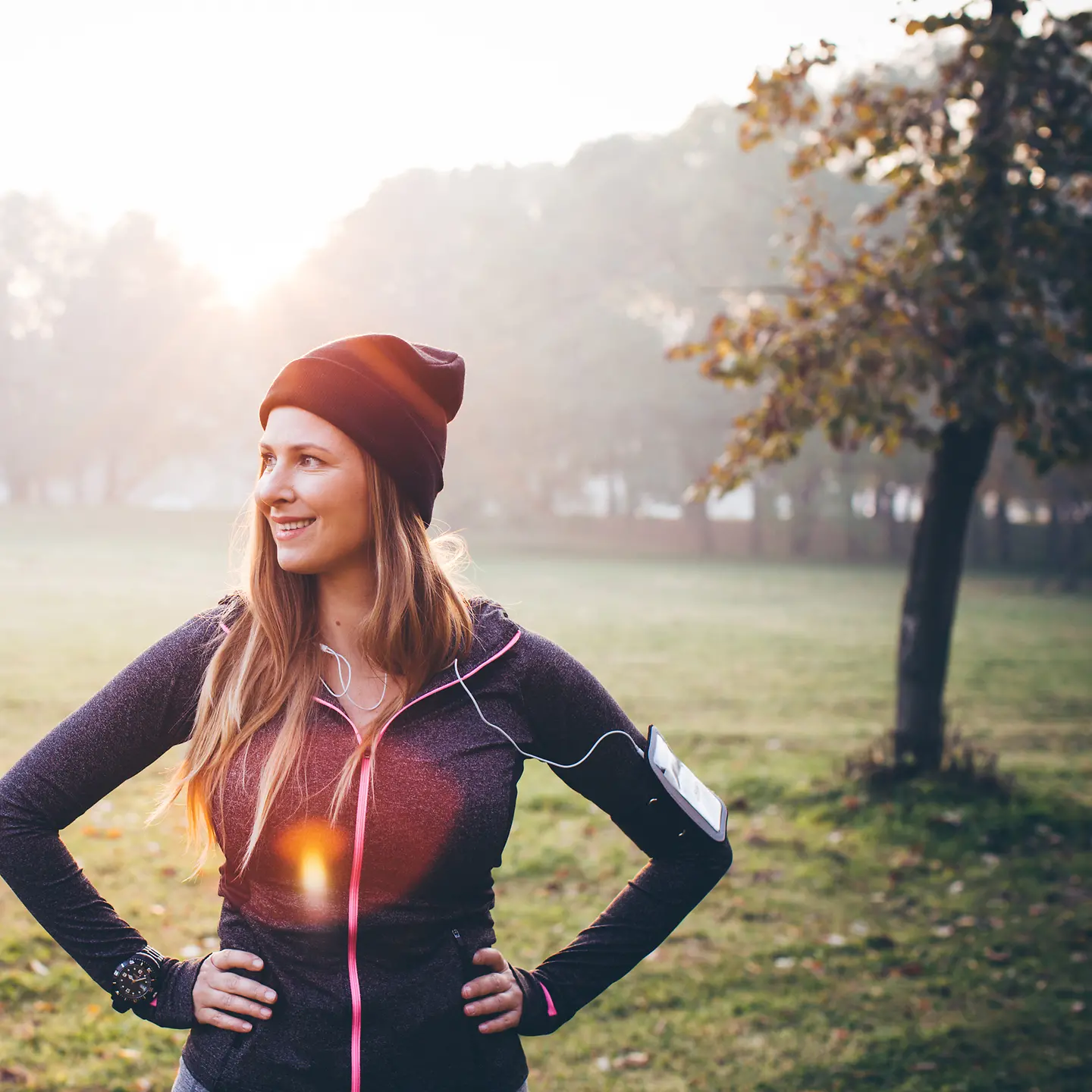 Eine junge Frau im Laufdress steht auf einer Wiese