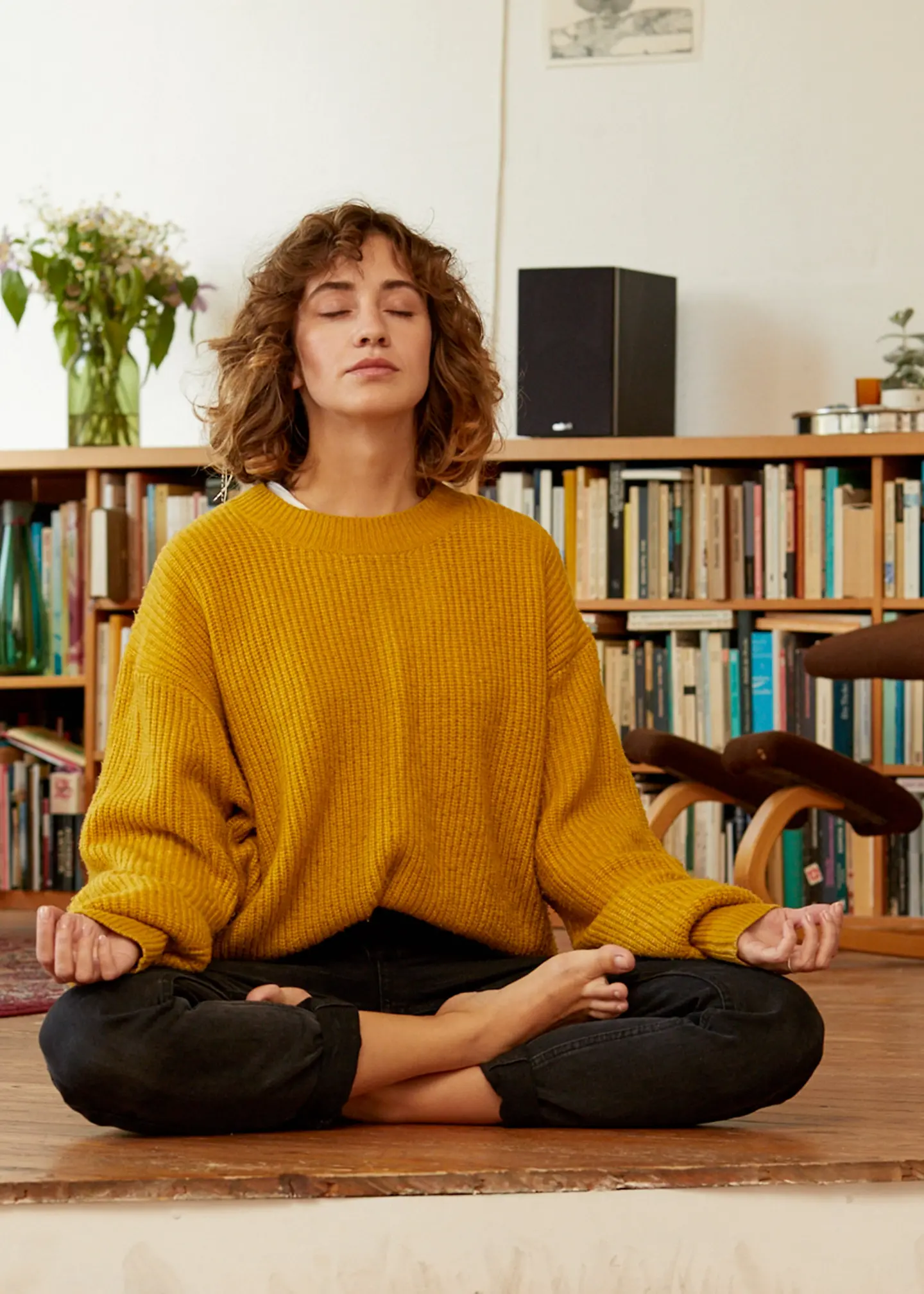 Eine Frau sitzt im Schneidersitz und mach Yoga