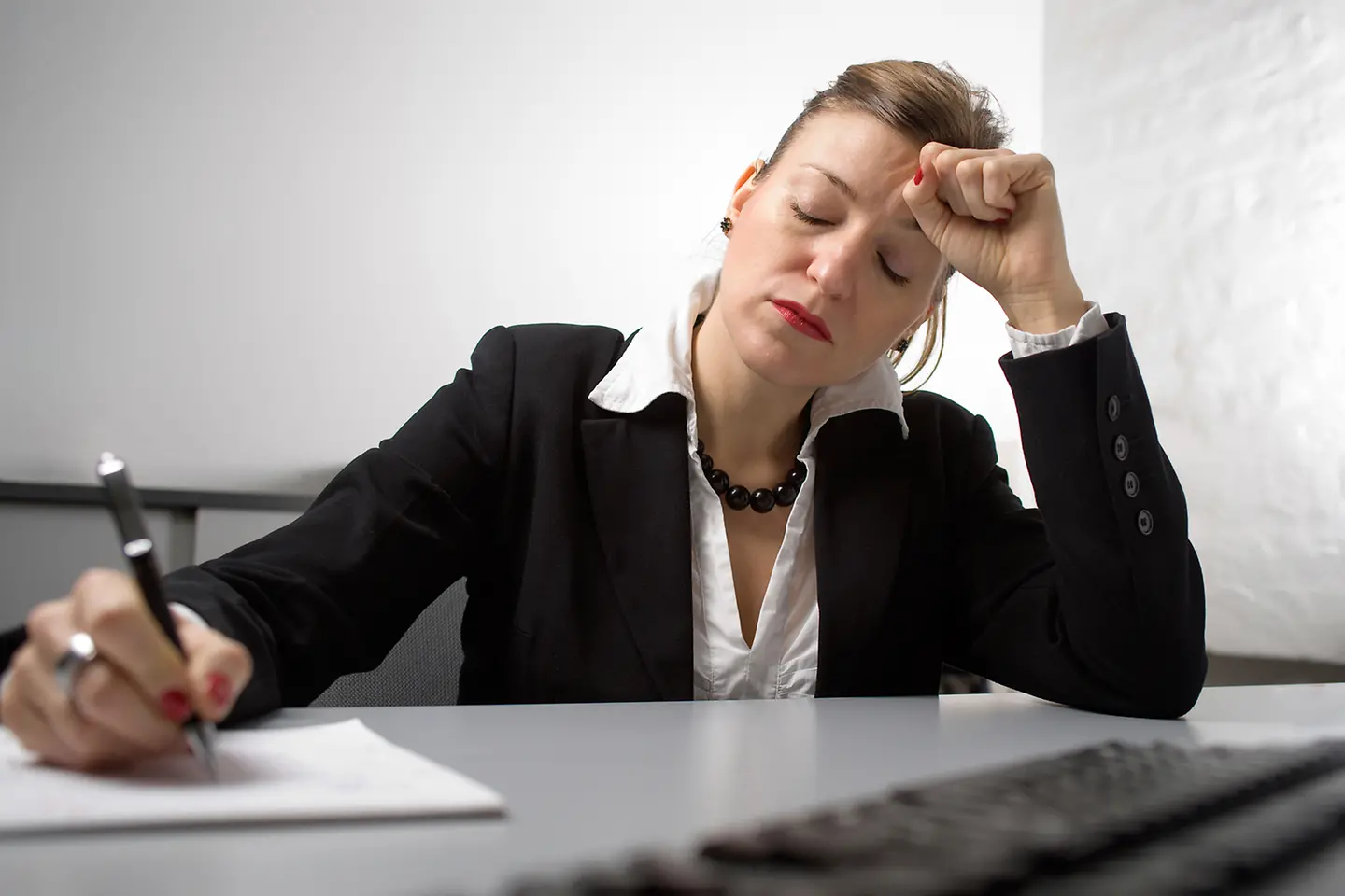 Erschöpfte Frau am Schreibtisch