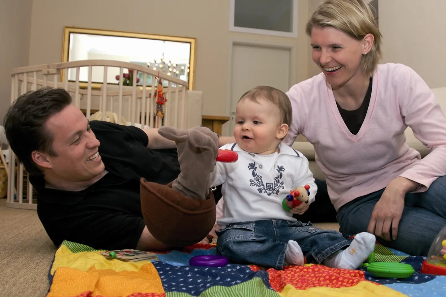 Dieses Bild zeigt eine spielende Familie mit einem Kleinkind