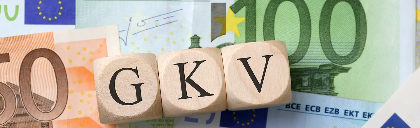 Das Bild zeigt verschiedene Euroscheine und Münzen auf denen drei Holzwürfel mit den Buchstaben GKV liegen.