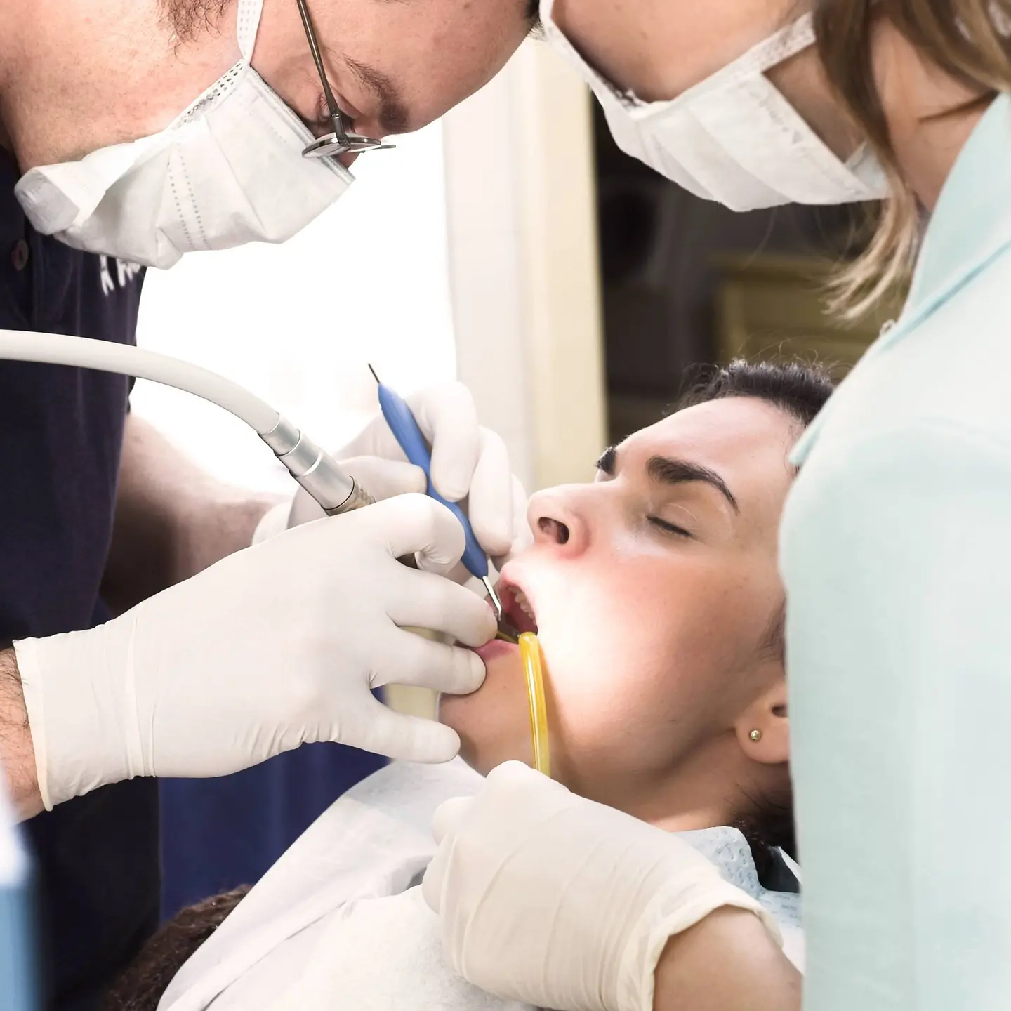 Zahnarzt und Assistentin behandeln Patientin