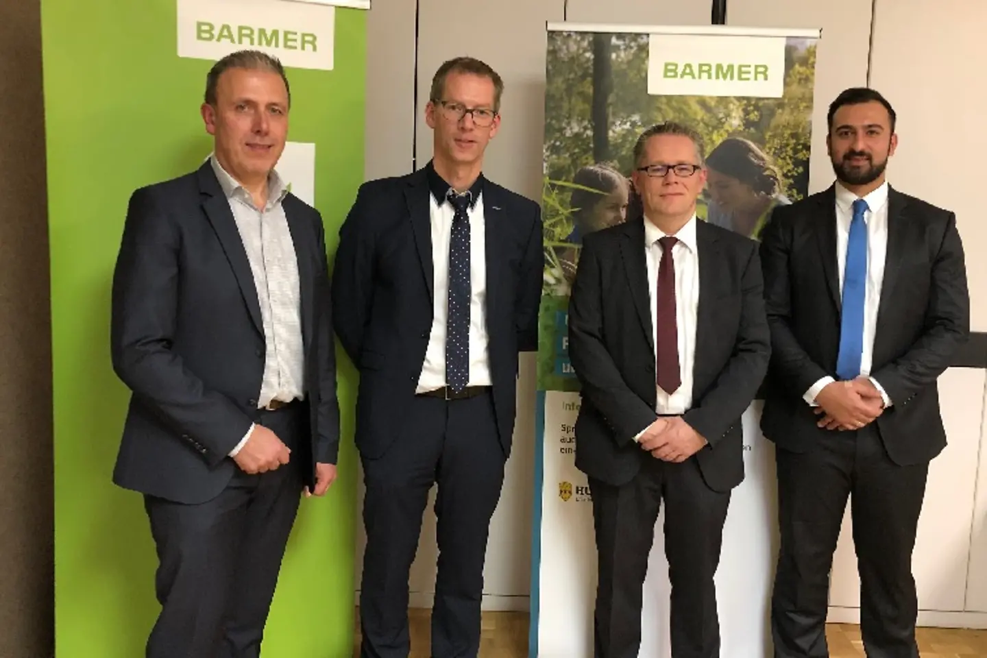 Die Referenten der Veranstaltung stehen vor einer Wand.