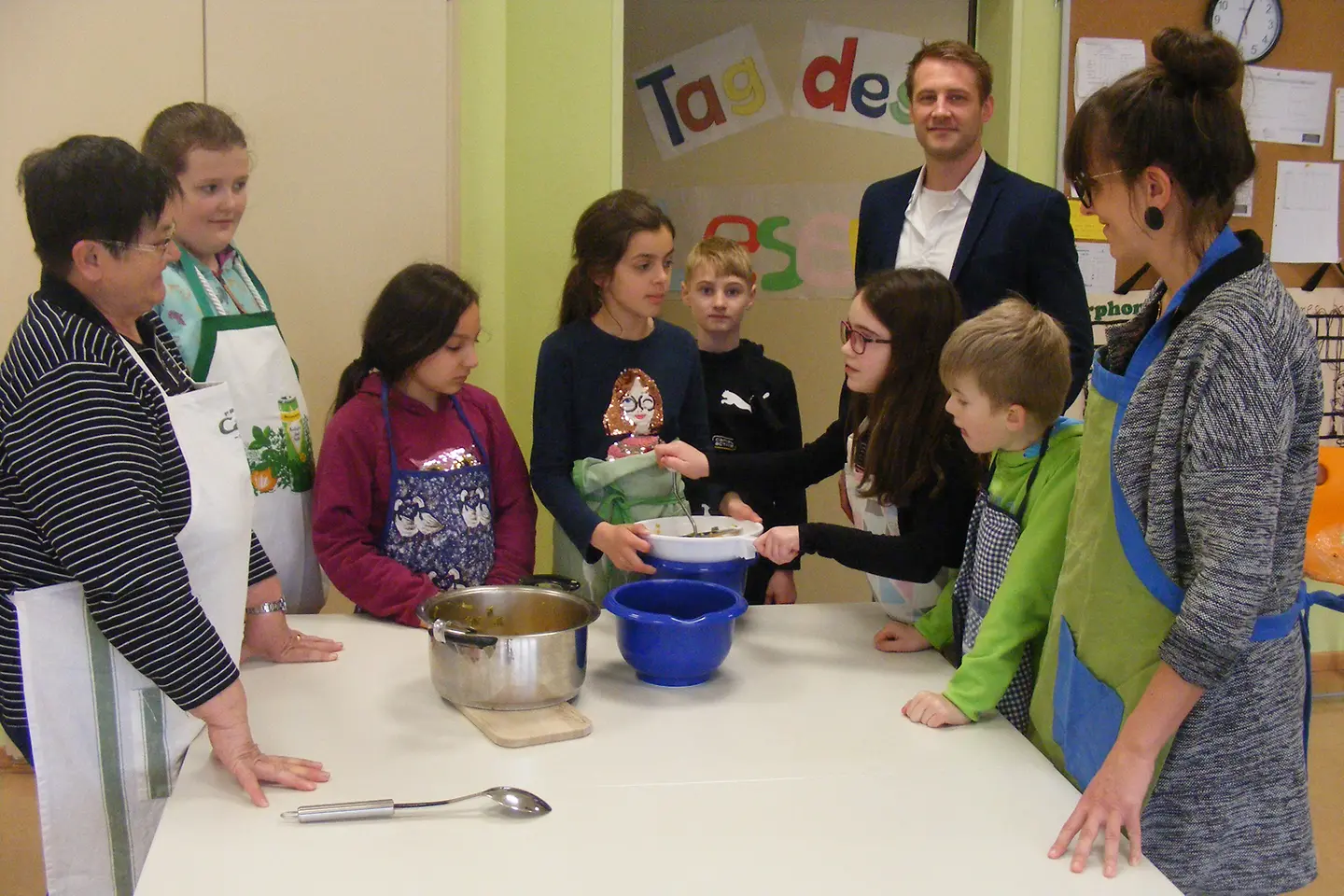 Kinder, zwei Lehrerinnen und ein BARMER Vertreter in der Schulküche