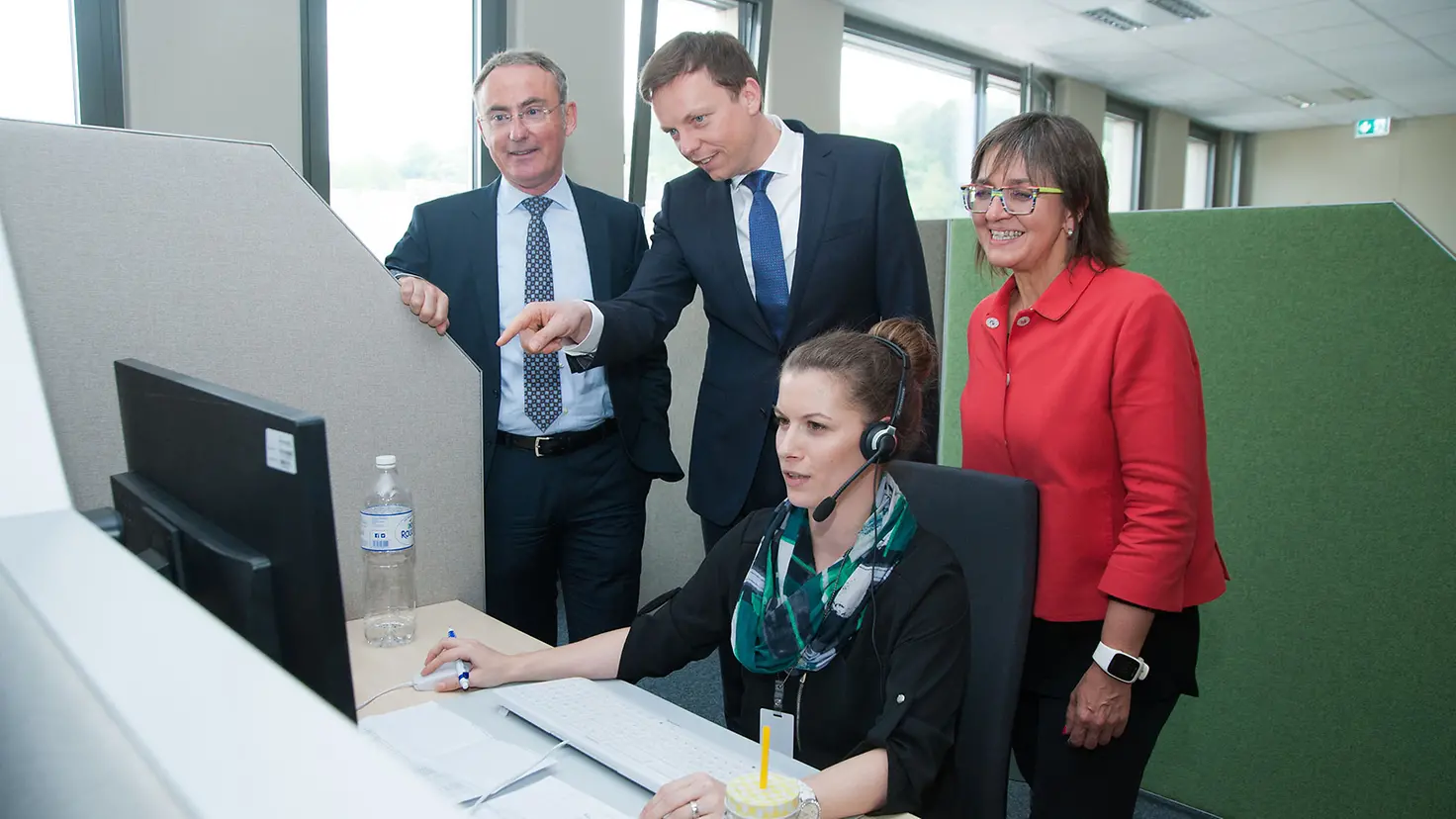 obias Hans, Prof. Dr. Christoph Straub und Dunja Kleis schauen einer Mitarbeiterin bei der Arbeit über die Schulter.