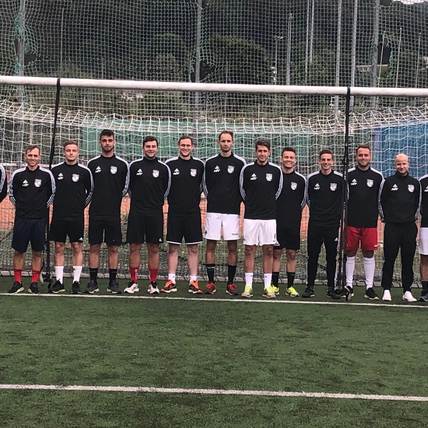 Mannschaft, Barmer-Vertreter, Trainer und sportlicher Leiter stehen vor einem Tor.