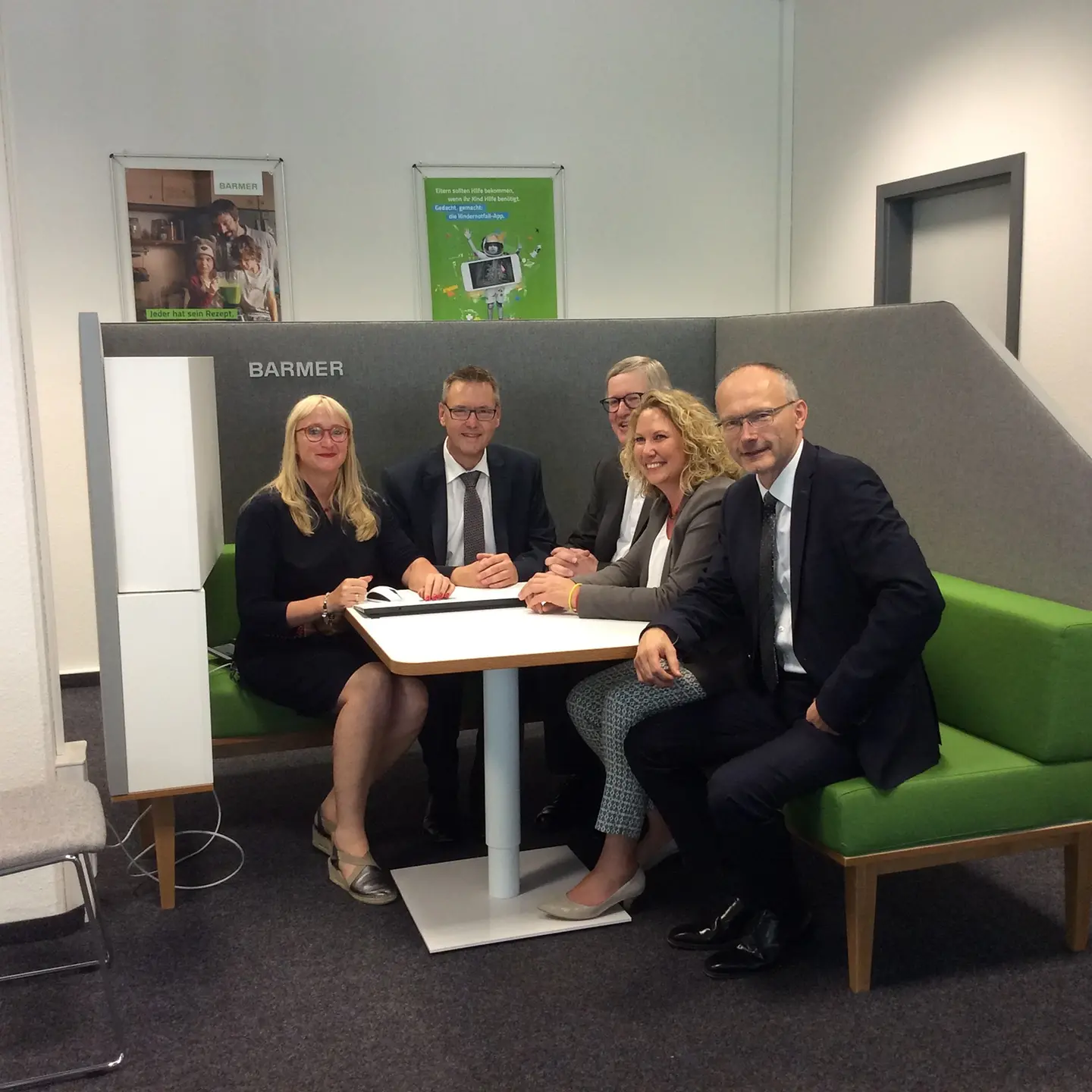 Barmer Mitarbeiter und Lokalpolitiker sitzen Probe in einer Beratungsecke der Geschäftsstelle.