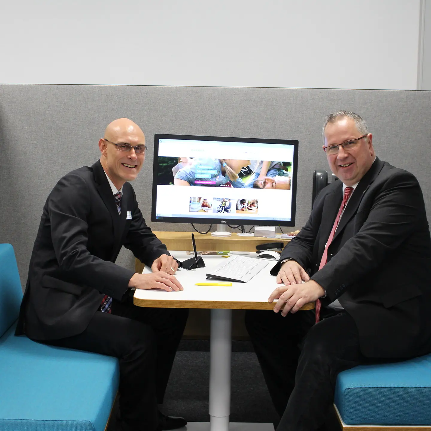 Der Oberbürgermeister von Homburg und der BARMER Regionalgeschäftsführer sitzen in einer Beratungsbox.