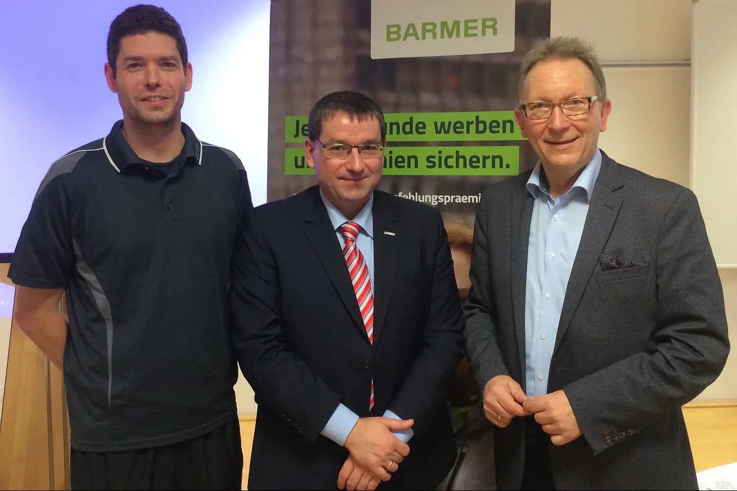 Die Referenten der Veranstaltung vor einem Roll-up.