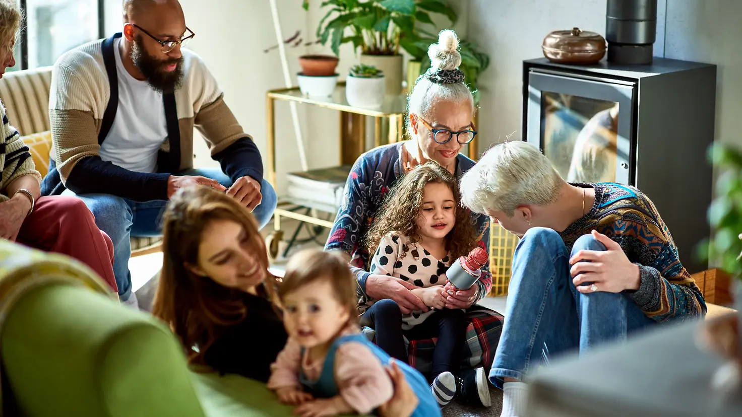 Drei Generationen einer Familie sitzen auf dem Wohnzimmerboden