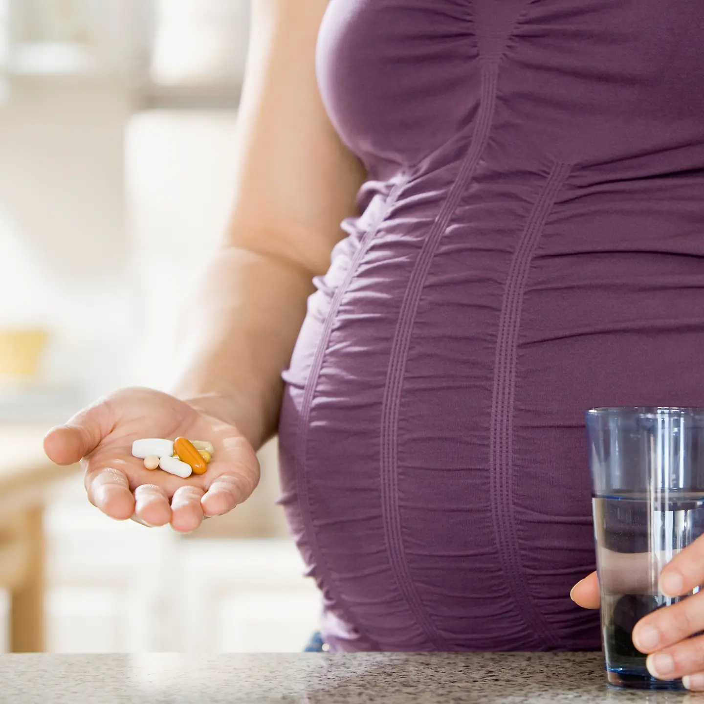Eine Schwangere nimmt Medikamente ein