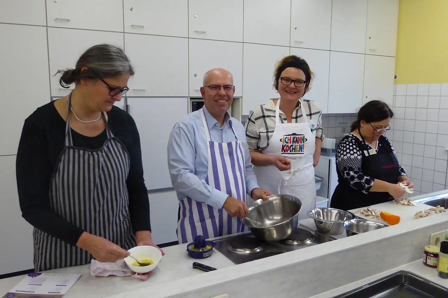 Trainerin, Oliver Hellriegel und angehende Genussbotschafter in der Küche beim Schnippeln.