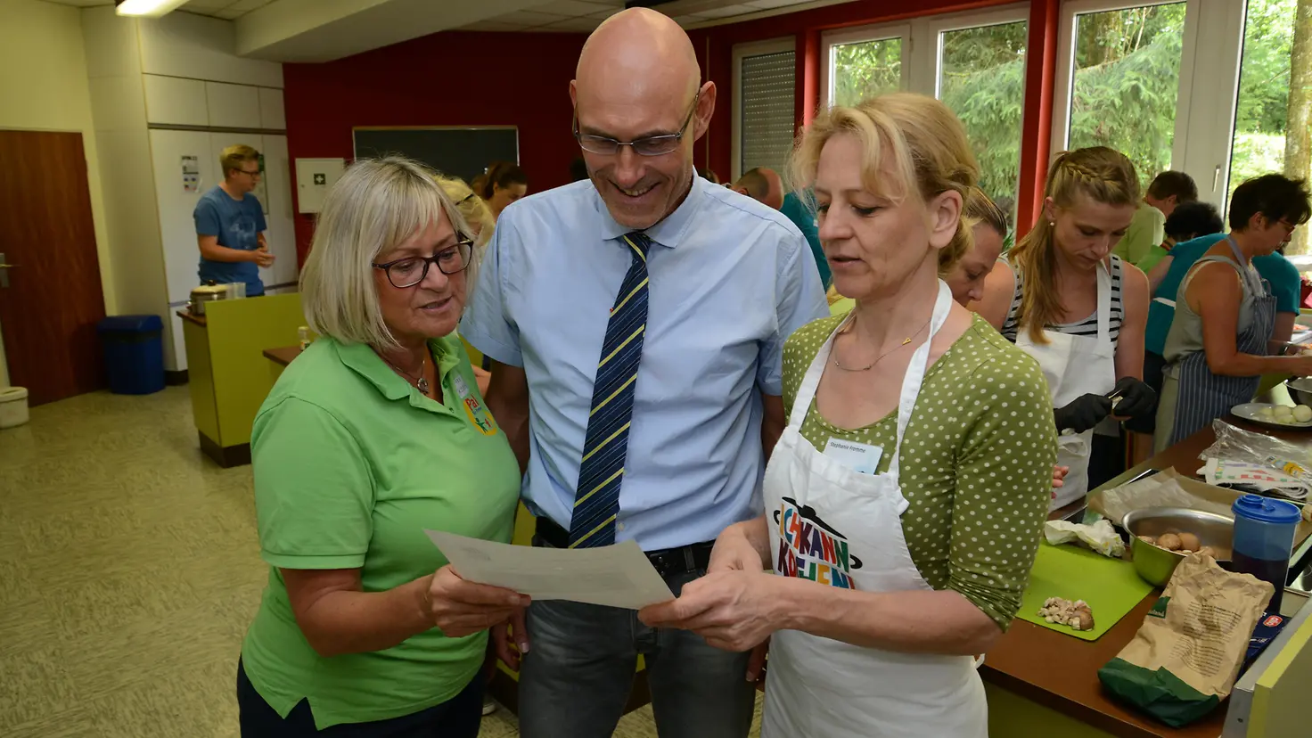 Hansjörg Lambrix, Sabine Kober und Stephanie Fromme mit angehenden Genussbotschaftern beim Kochen.