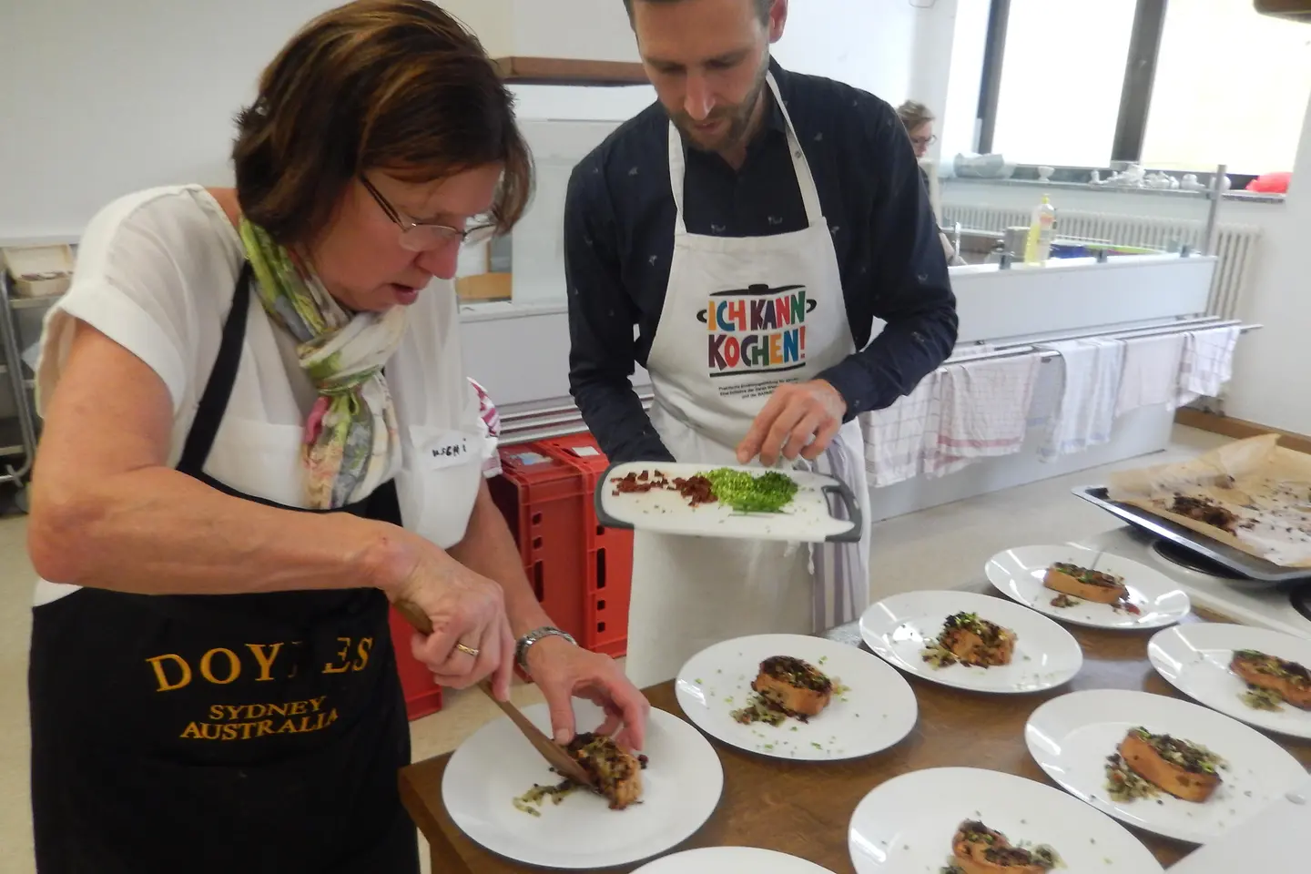 Workshop-Trainer und angehende Genussbotschafterin bereiten Speisen zu.
