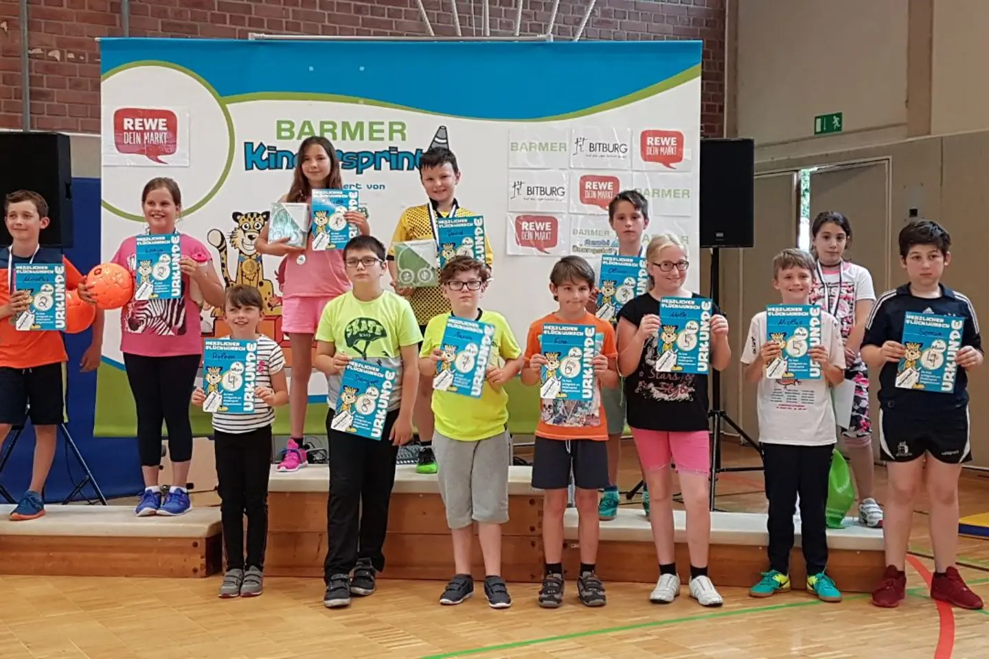 Kinder zeigen ihre Siegerurkunden