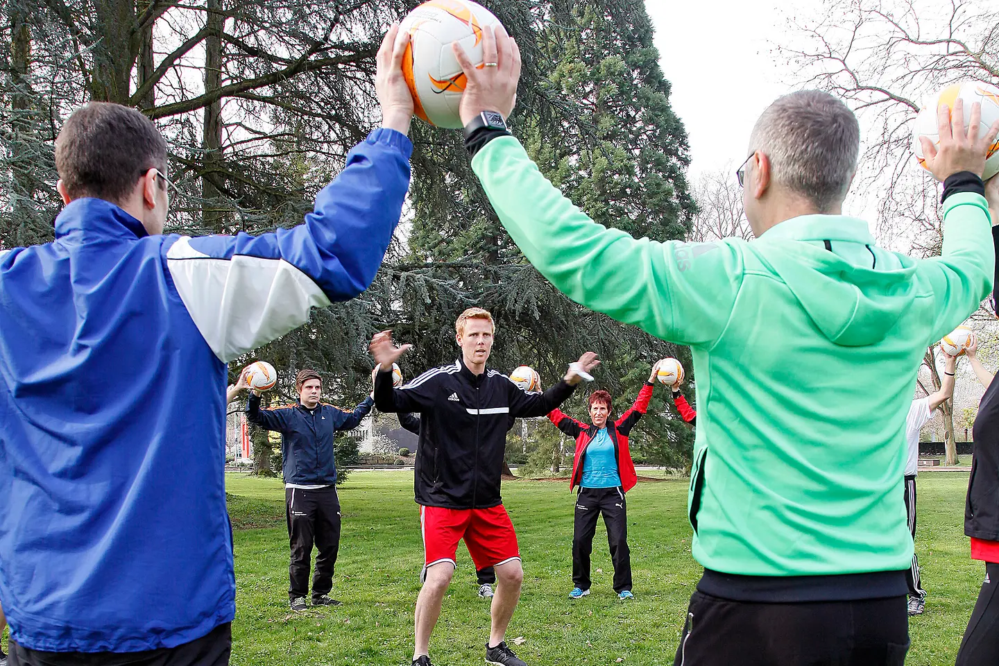 Jonas Reckermann trainiert mit Sparkassen-Mitarbeitern im Park.