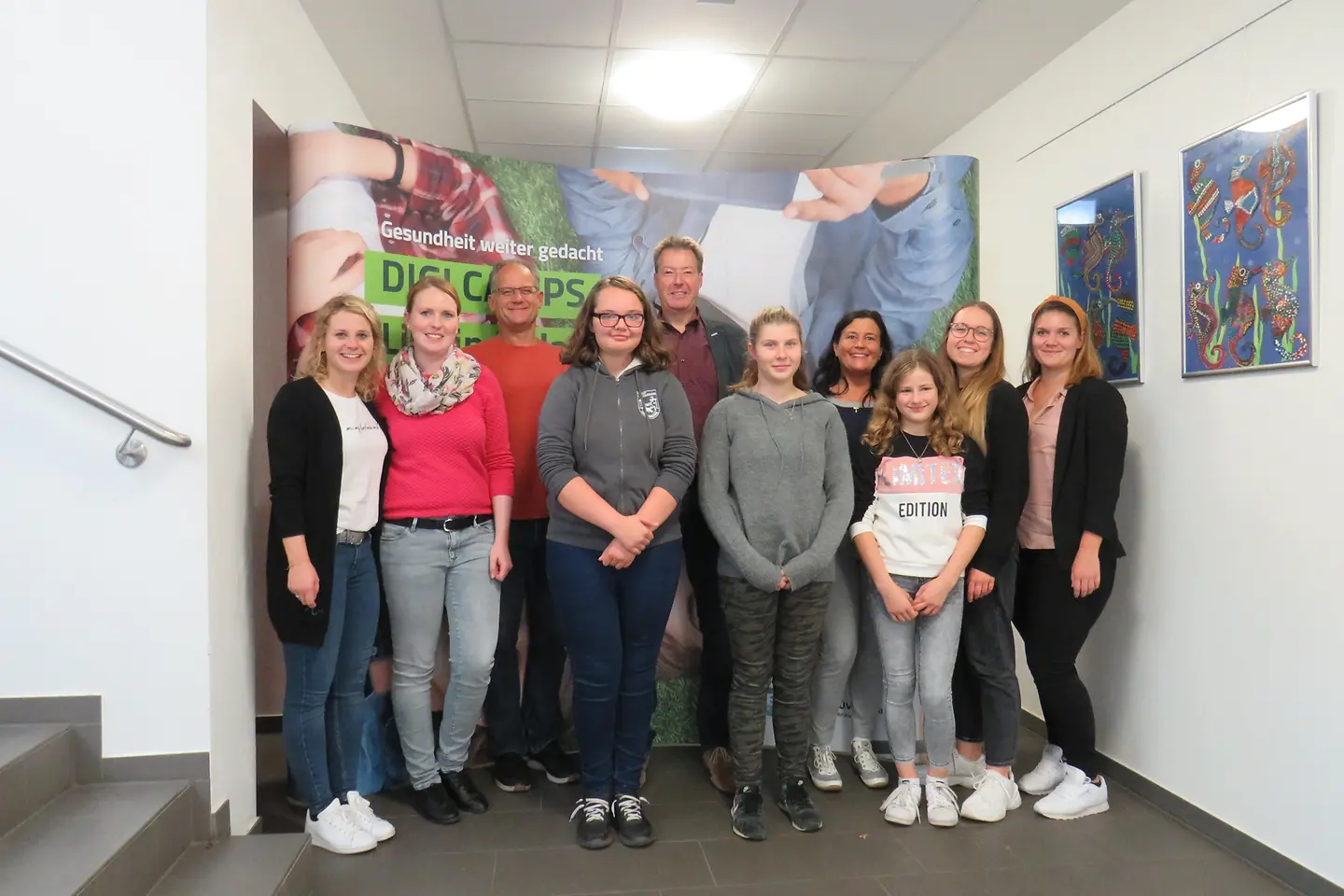 Lehrer, Schüler und Digitalexperten stehen zum Gruppenbild beisammen