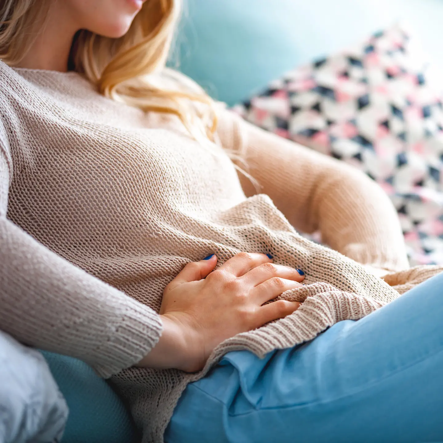 Das Bild zeigt eine Frau mit Unterleibschmerzen