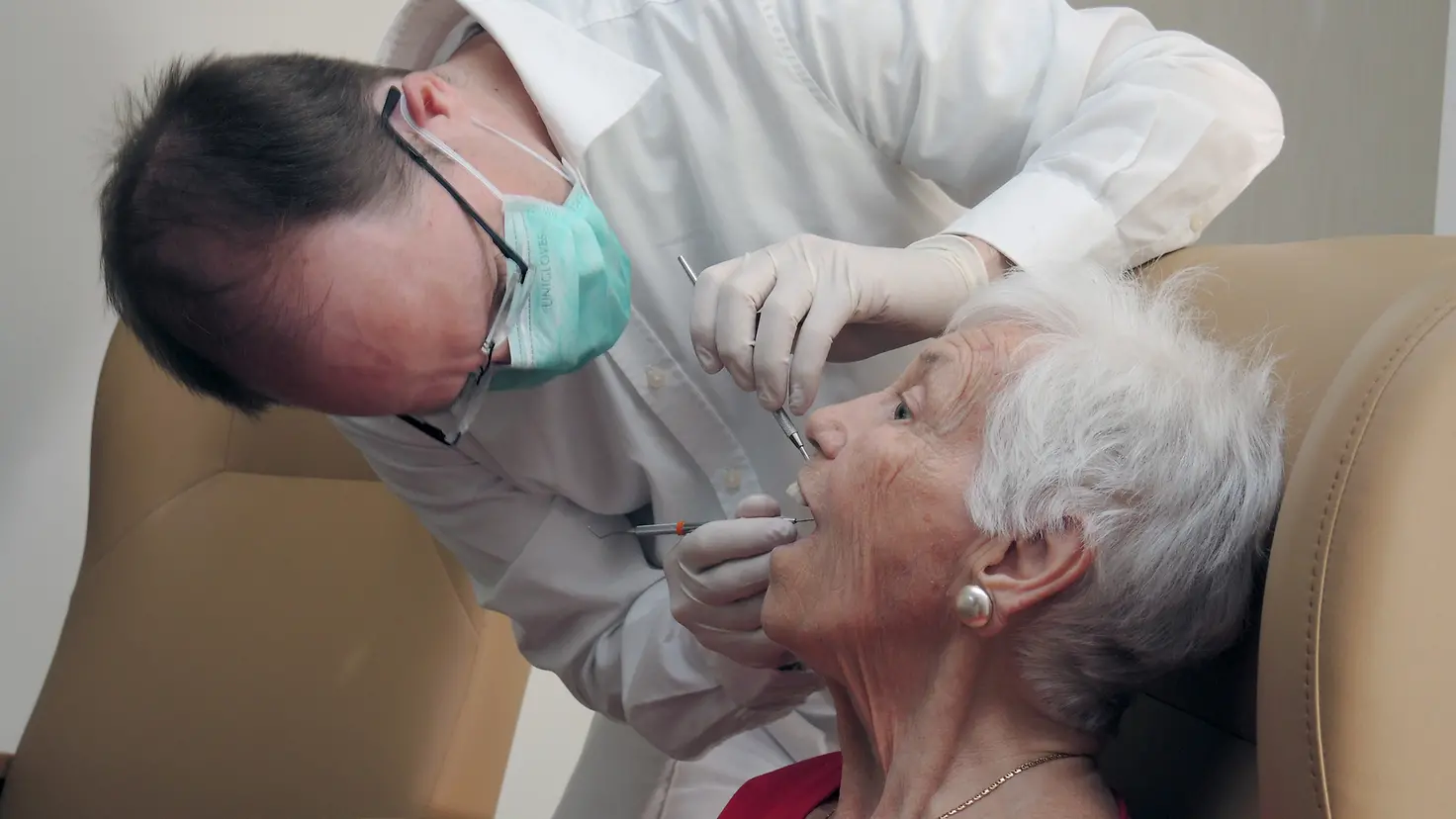 Eine Seniorin bei einer zahnärztlichen Untersuchung.