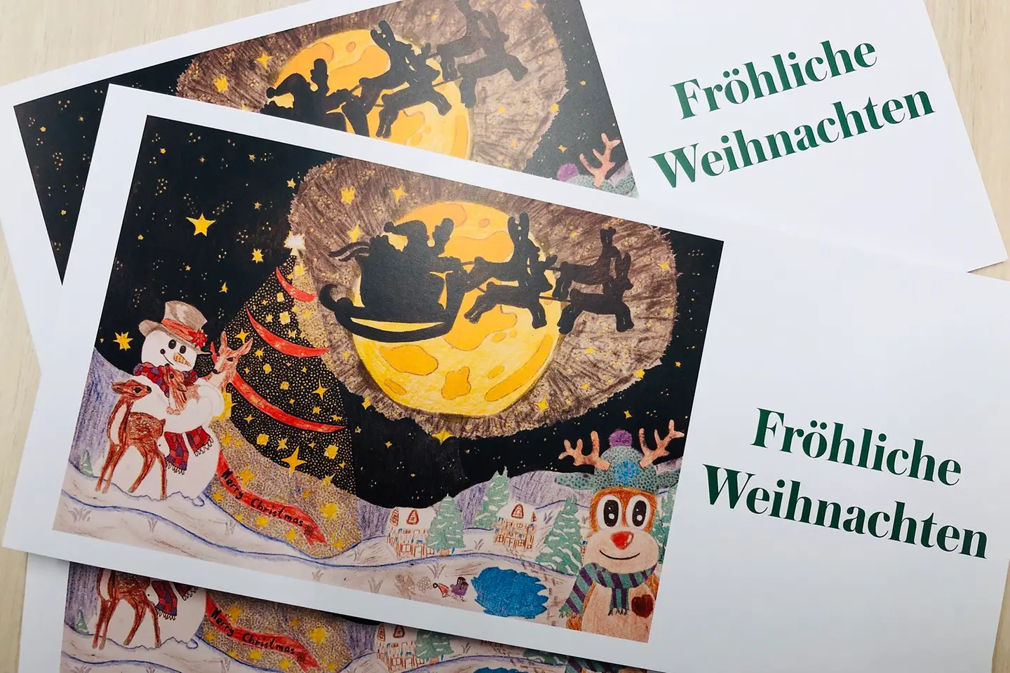 Die fertige Weihnachtskarte mit Lucies Bild, welches den Weihnachtsmann im Rentierschlitten zeigt 