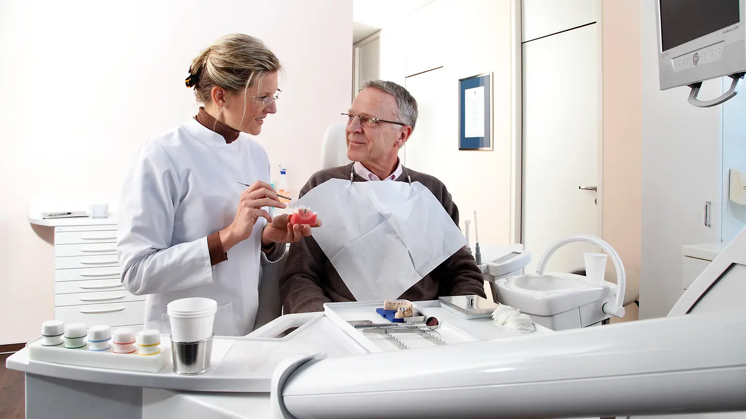 Ein Patient beim Aufklärungsgespräch einer Zahnärztin in der Praxis.