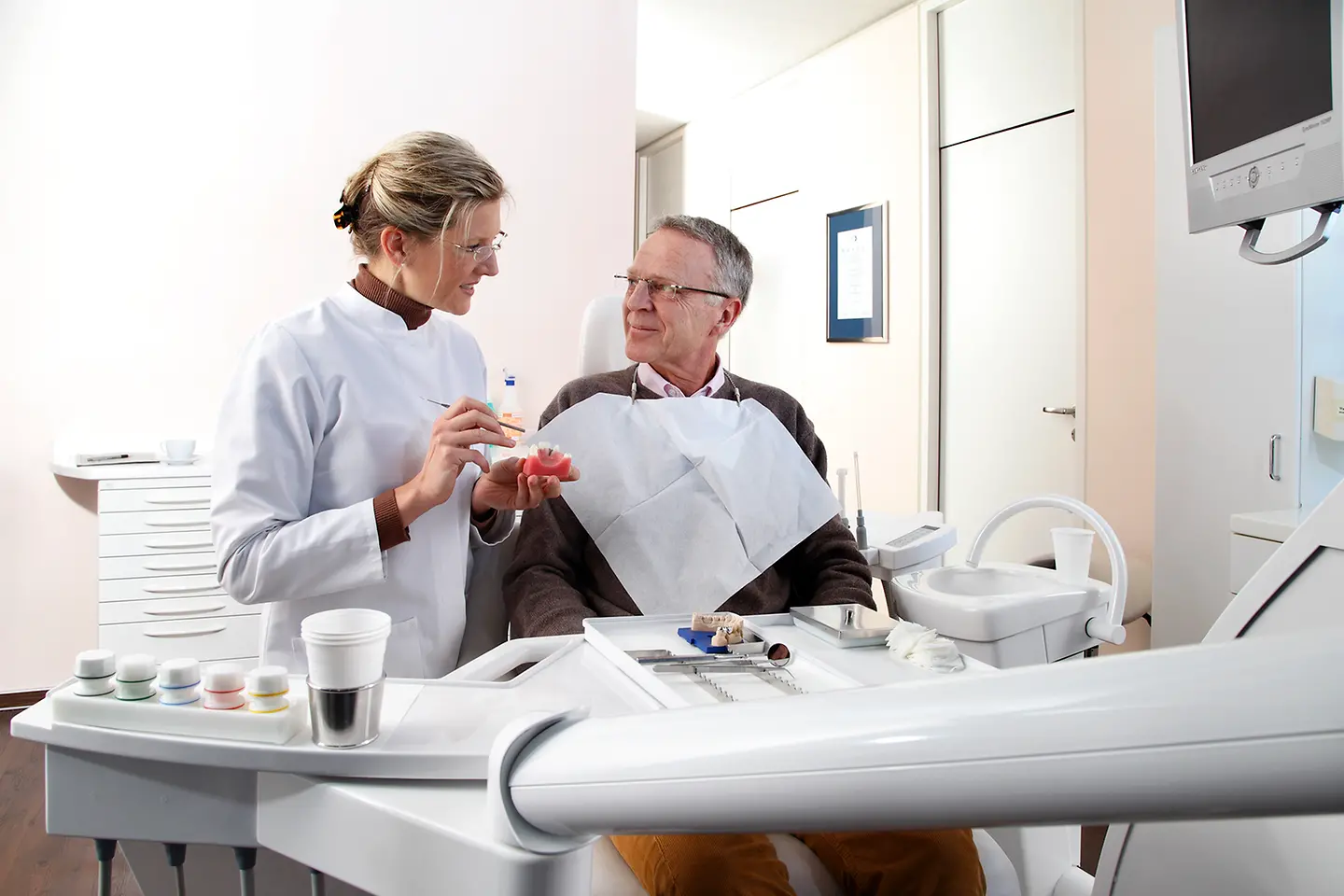 Ein Patient beim Aufklärungsgespräch einer Zahnärztin in der Praxis.