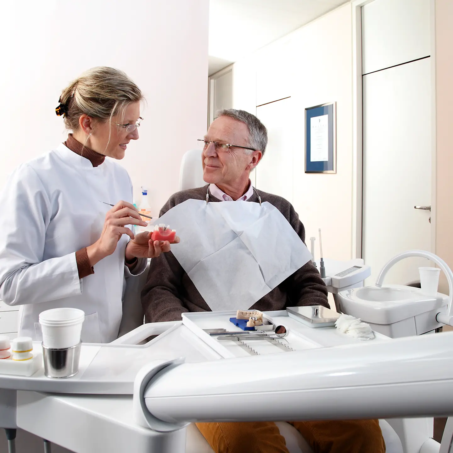 Ein Patient beim Aufklärungsgespräch einer Zahnärztin in der Praxis.