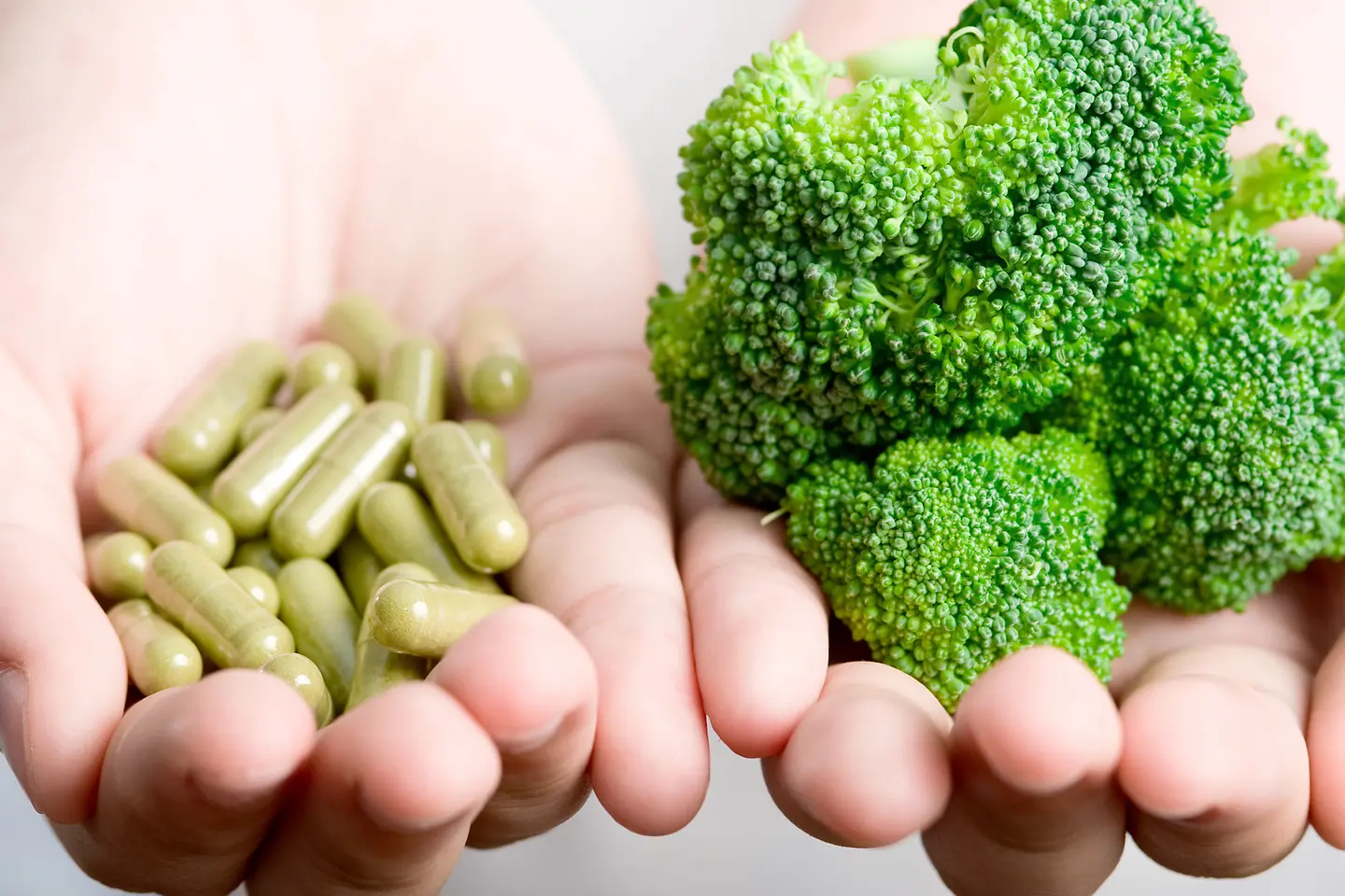 Brokkoli und grüne Kapseln liegen in einer Hand