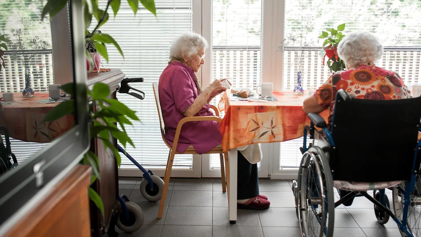 Ältere Damen sitzen am Tisch in einem Pflegeheim