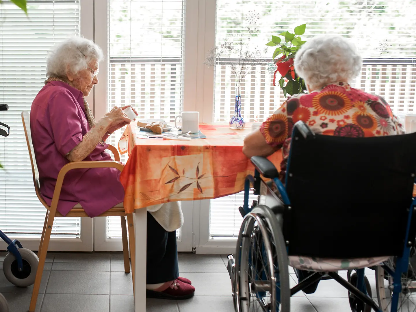 Ältere Damen sitzen am Tisch in einem Pflegeheim