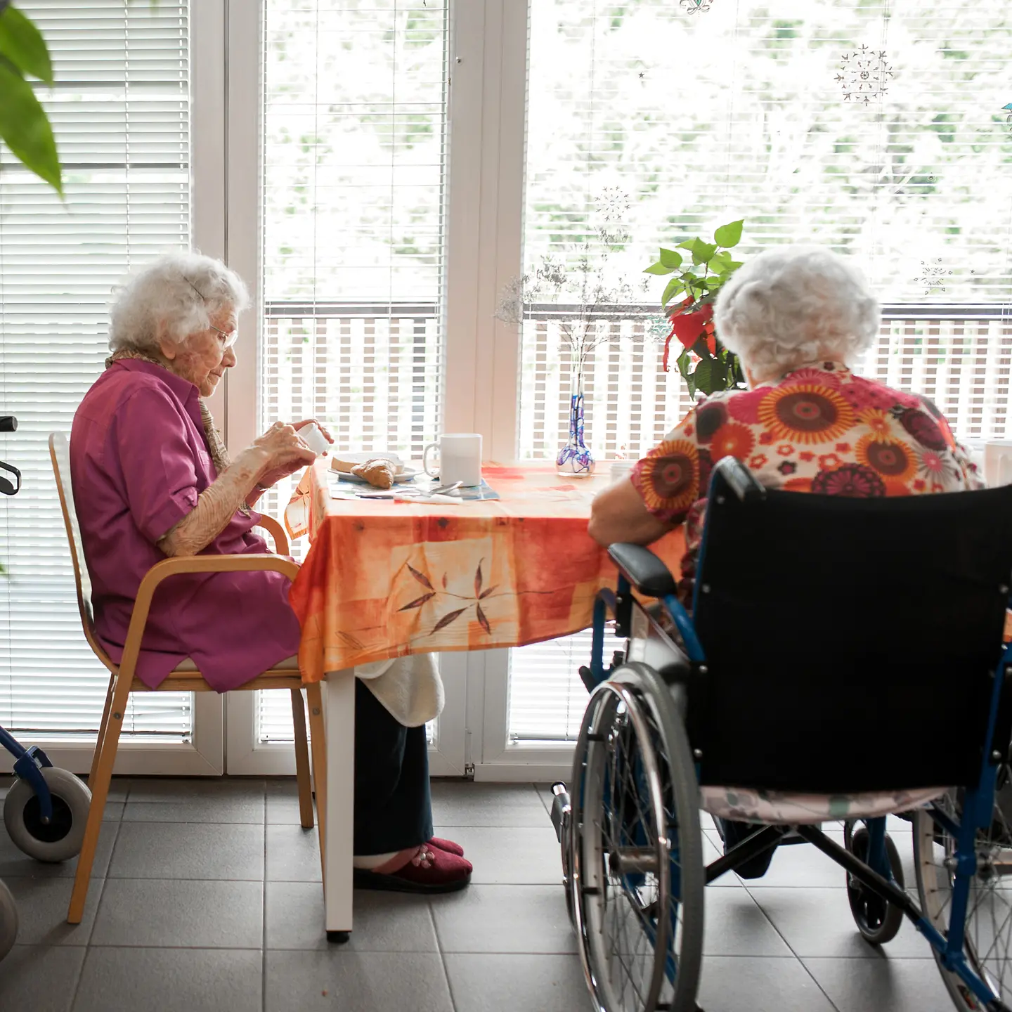 Ältere Damen sitzen am Tisch in einem Pflegeheim
