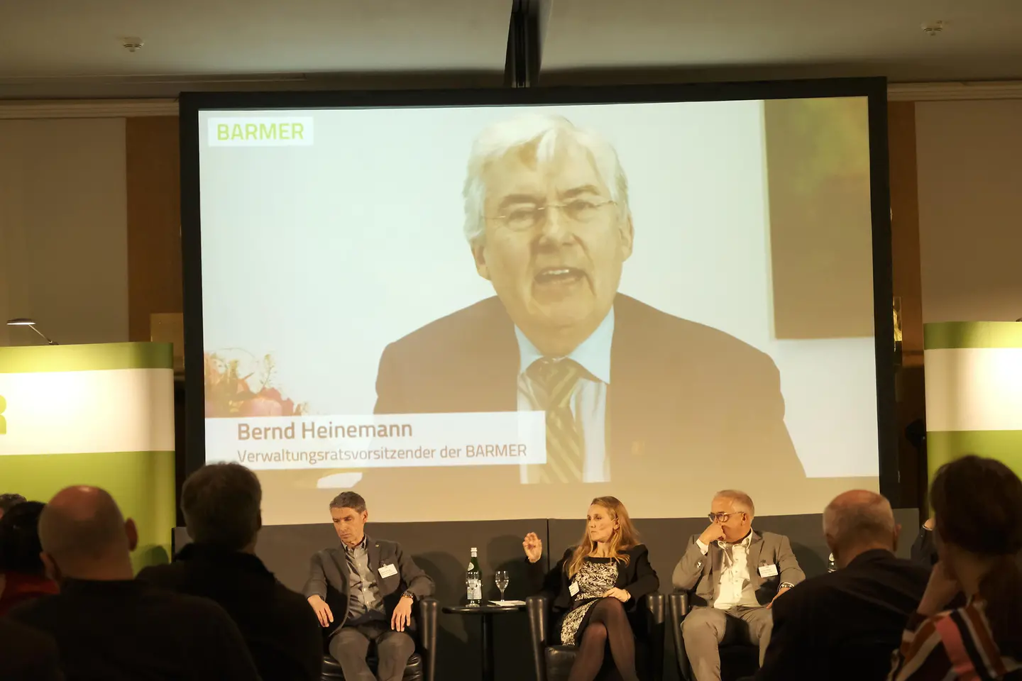 Teilnehmer auf dem Podium und per Video