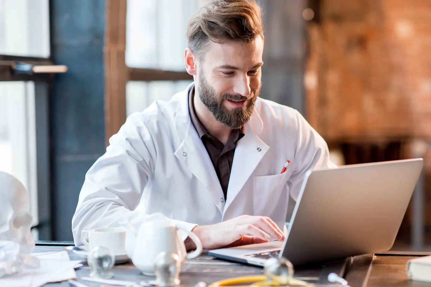 Ein Arzt arbeitet an seinem Laptop