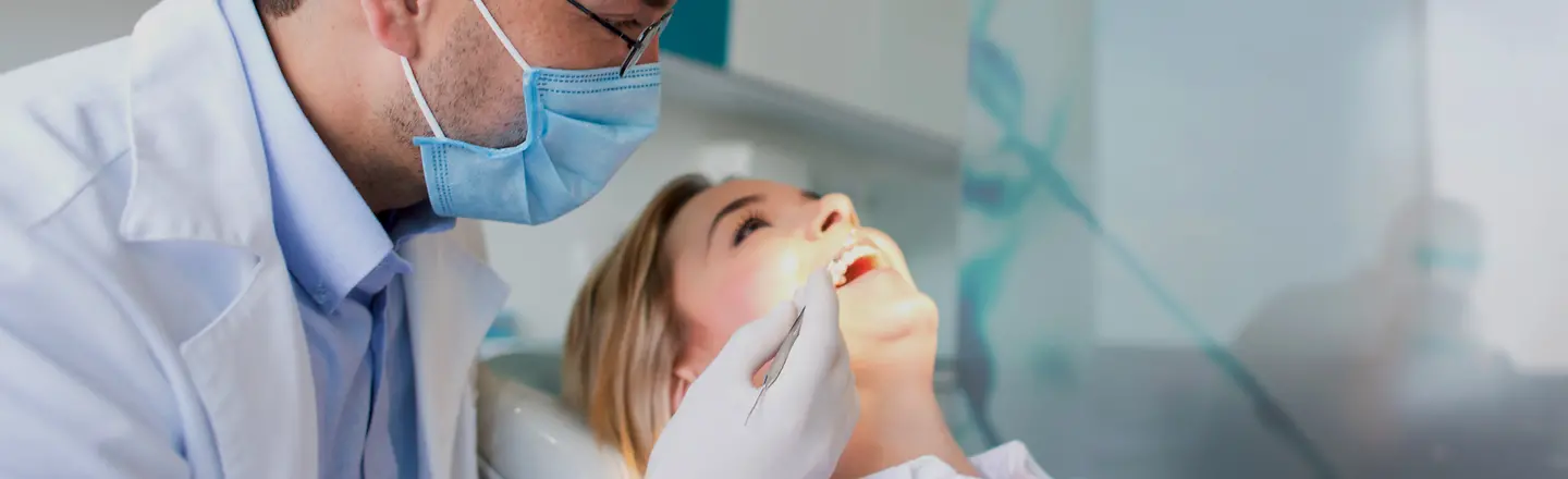 Eine Frau wird von einem Zahnarzt untersucht