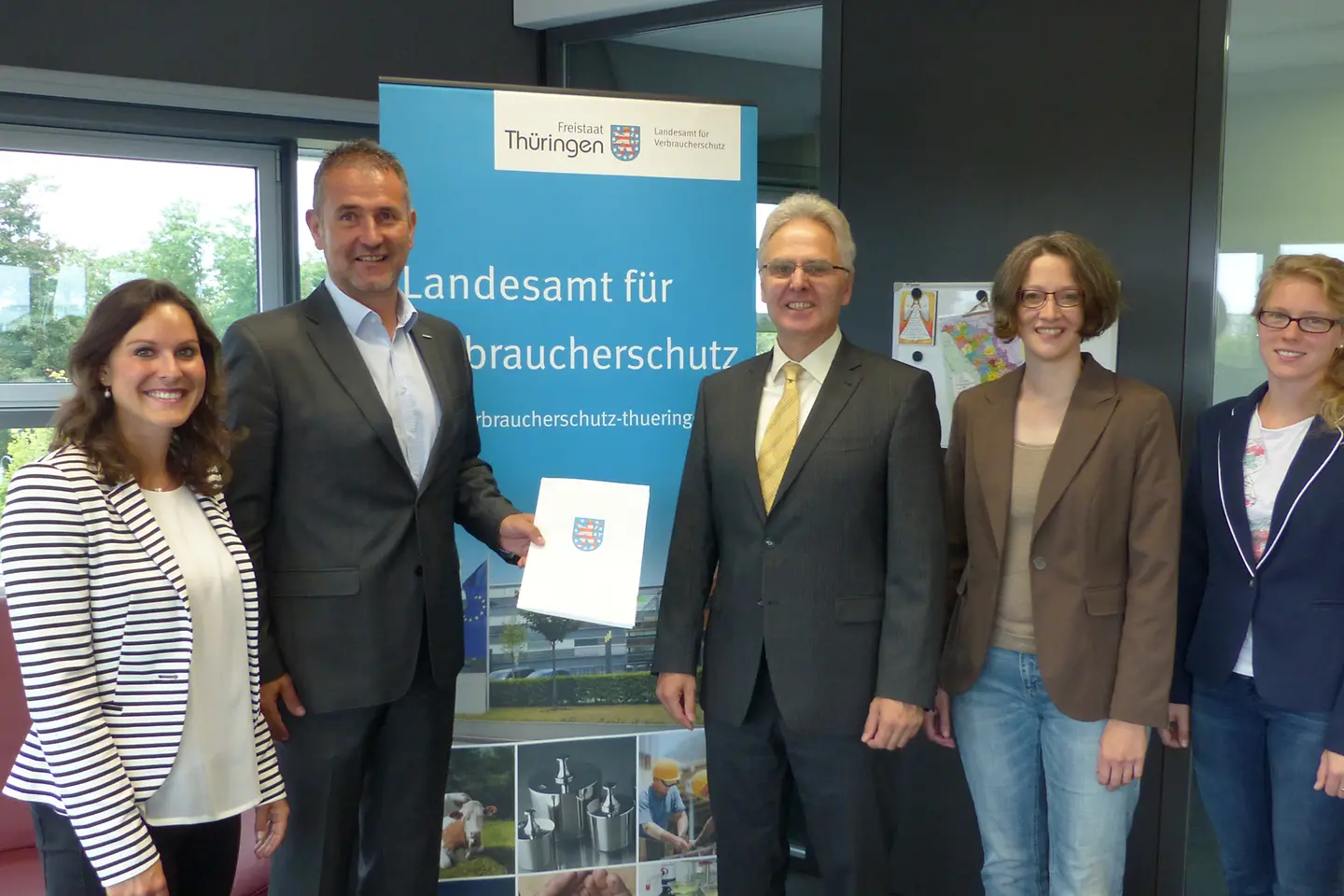 Gruppenfoto der Teilnehmer mit Vertrag