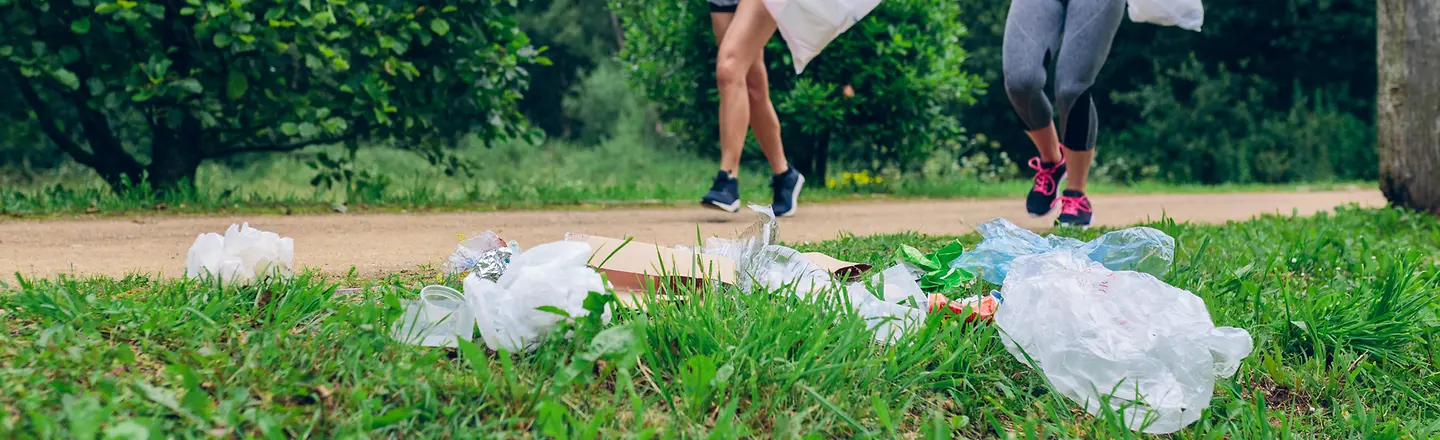 Das Bild zeigt zwei Frauen beim Joggen mit Mülltüten zum Müllsammeln.