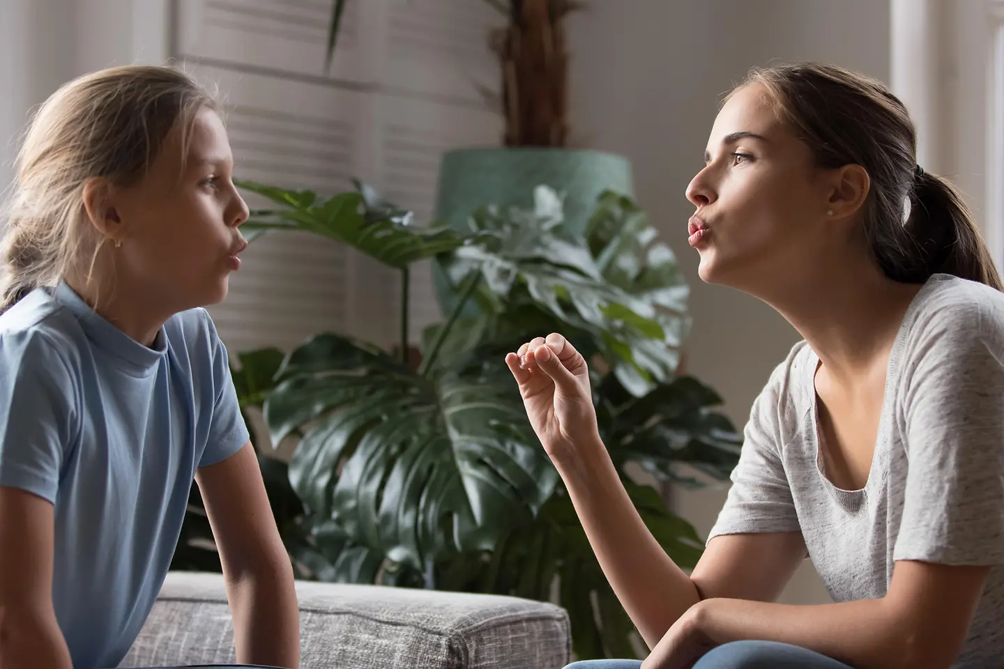 Das Bild zeigt eine Frau und ein Mädchen bei Sprachübungen.