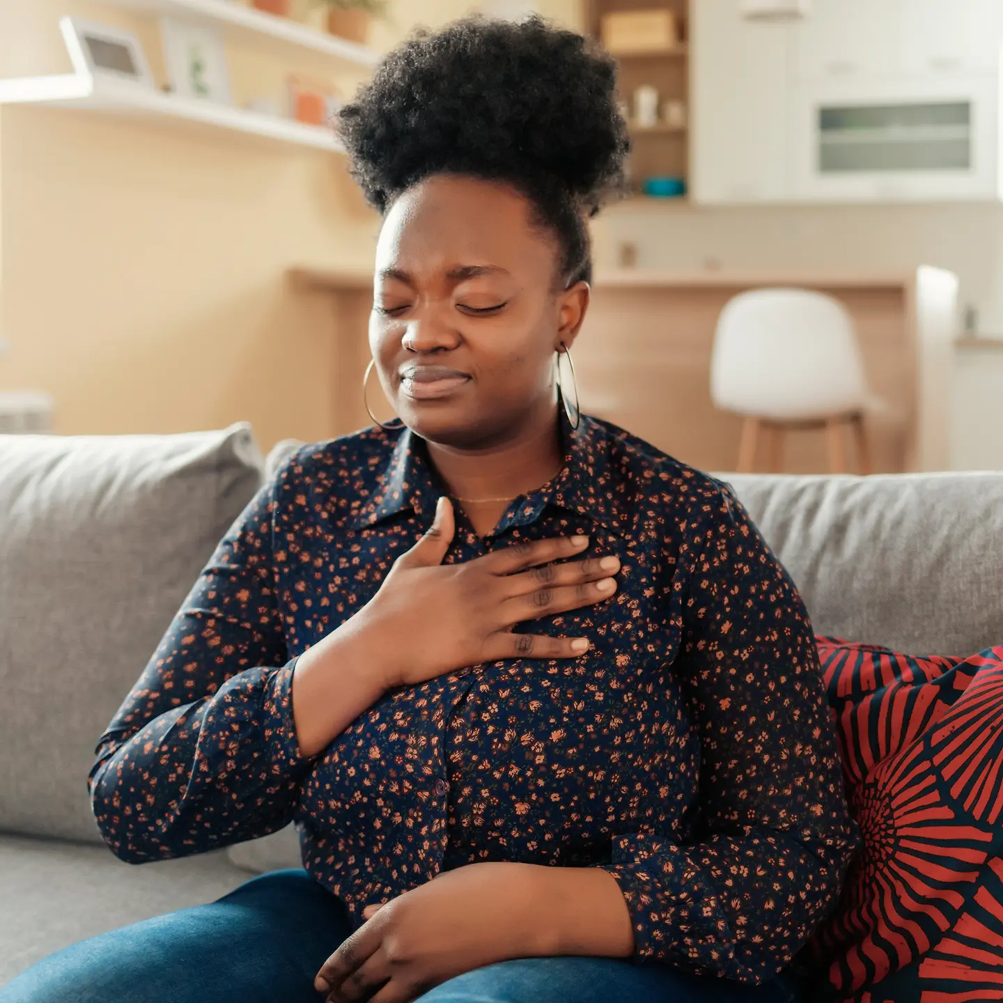 Eine junge Frau hält sich eine Hand vor den Brustkorb. 