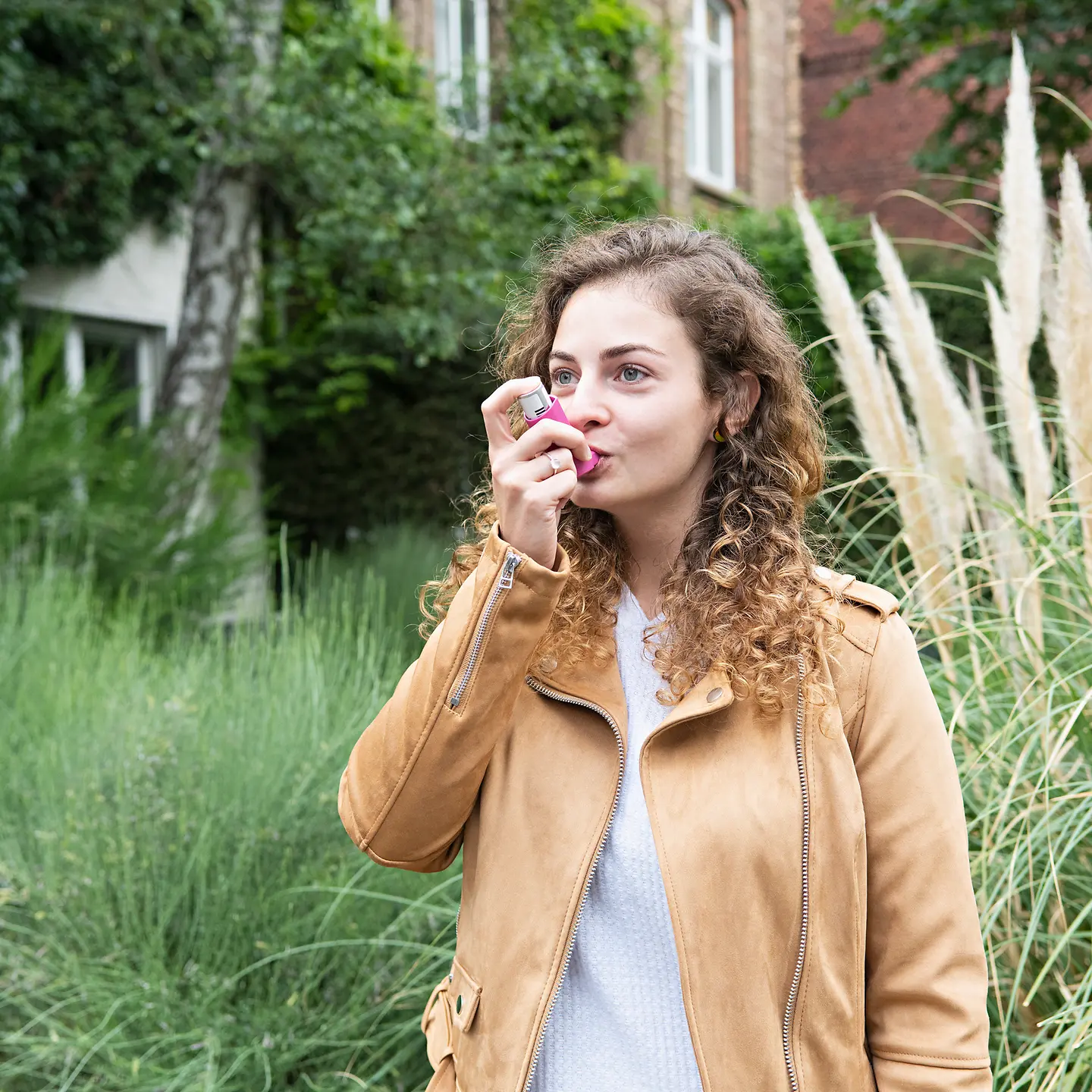 Eine junge Frau inhaliert ein Medikament gegen Asthma.