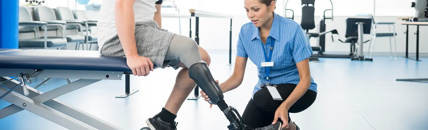 Ein Mann mit Beinprothese wird von einer Ärztin behandelt
