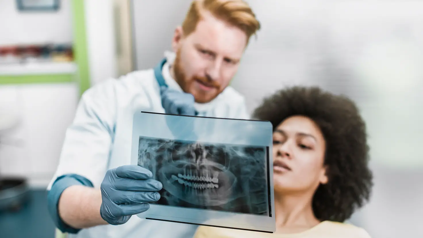 Zahnarzt erklärt einer Patientin ein Röntgenbild