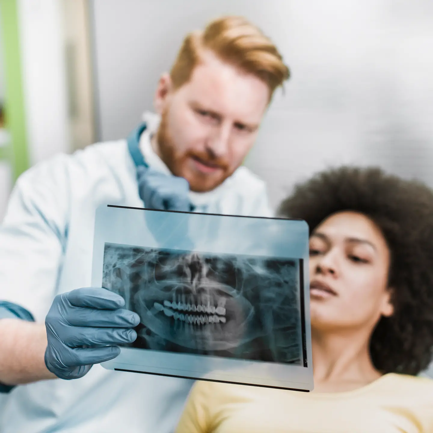Zahnarzt erklärt einer Patientin ein Röntgenbild