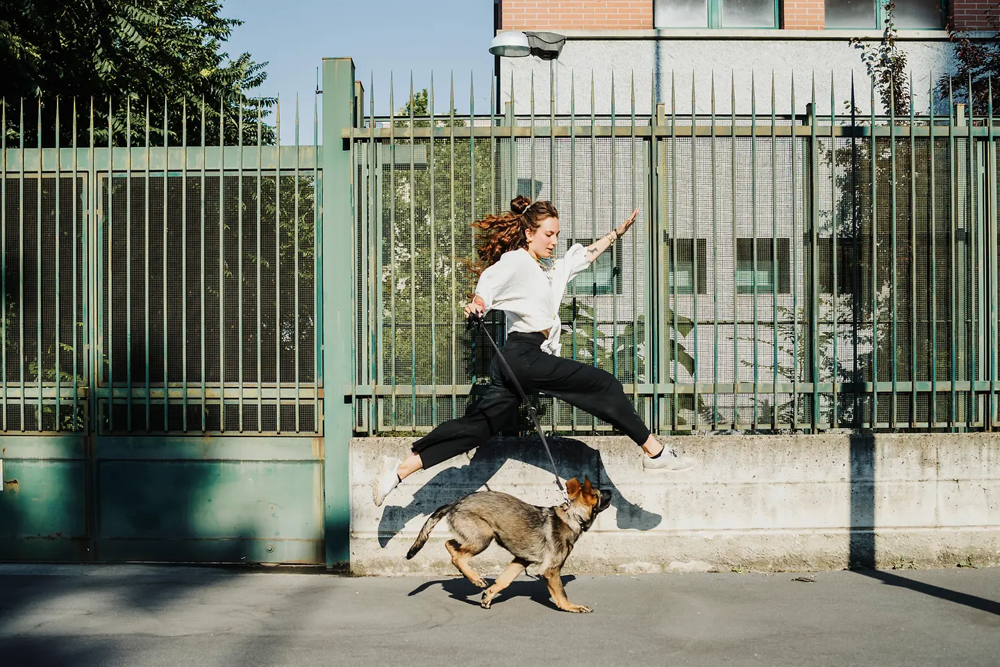 Eine junge Frau geht mit ihrem Hund spazieren.