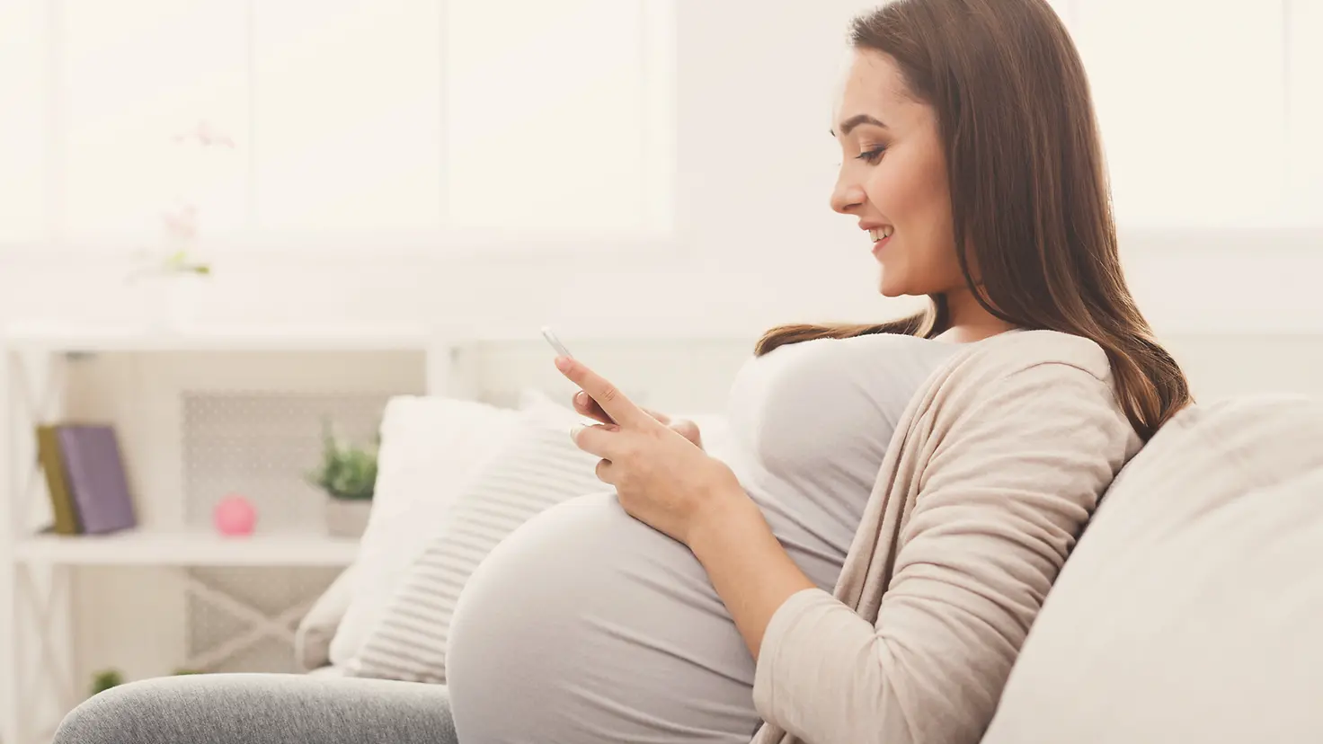 Schwangere Frau mit Smartphone