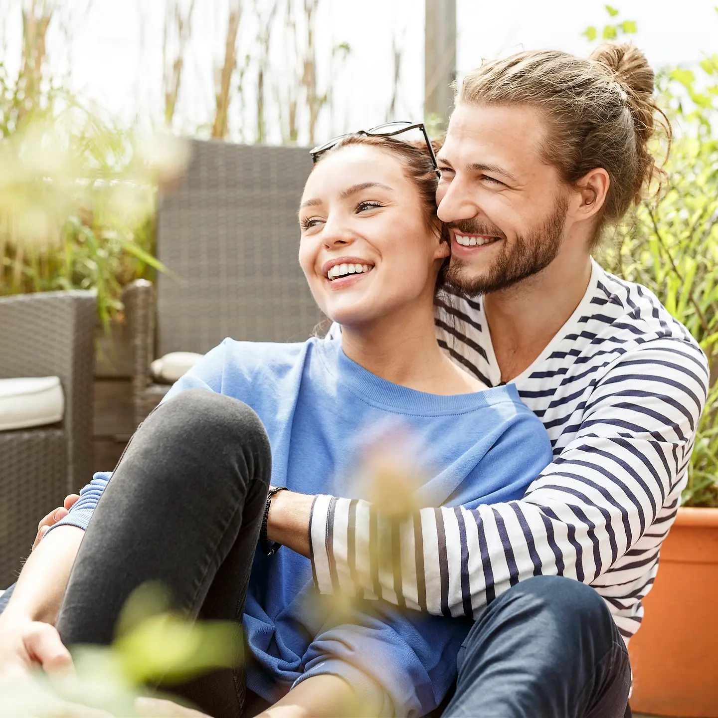 Ein junges Paar sitzt gemeinsam auf einer Terrasse
