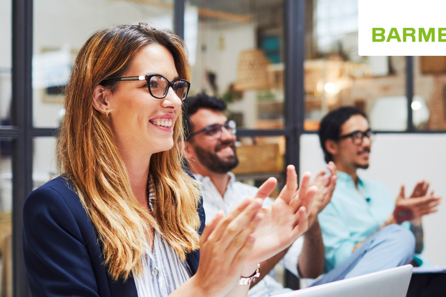 Blick auf drei sitzende Personen, die applaudieren.