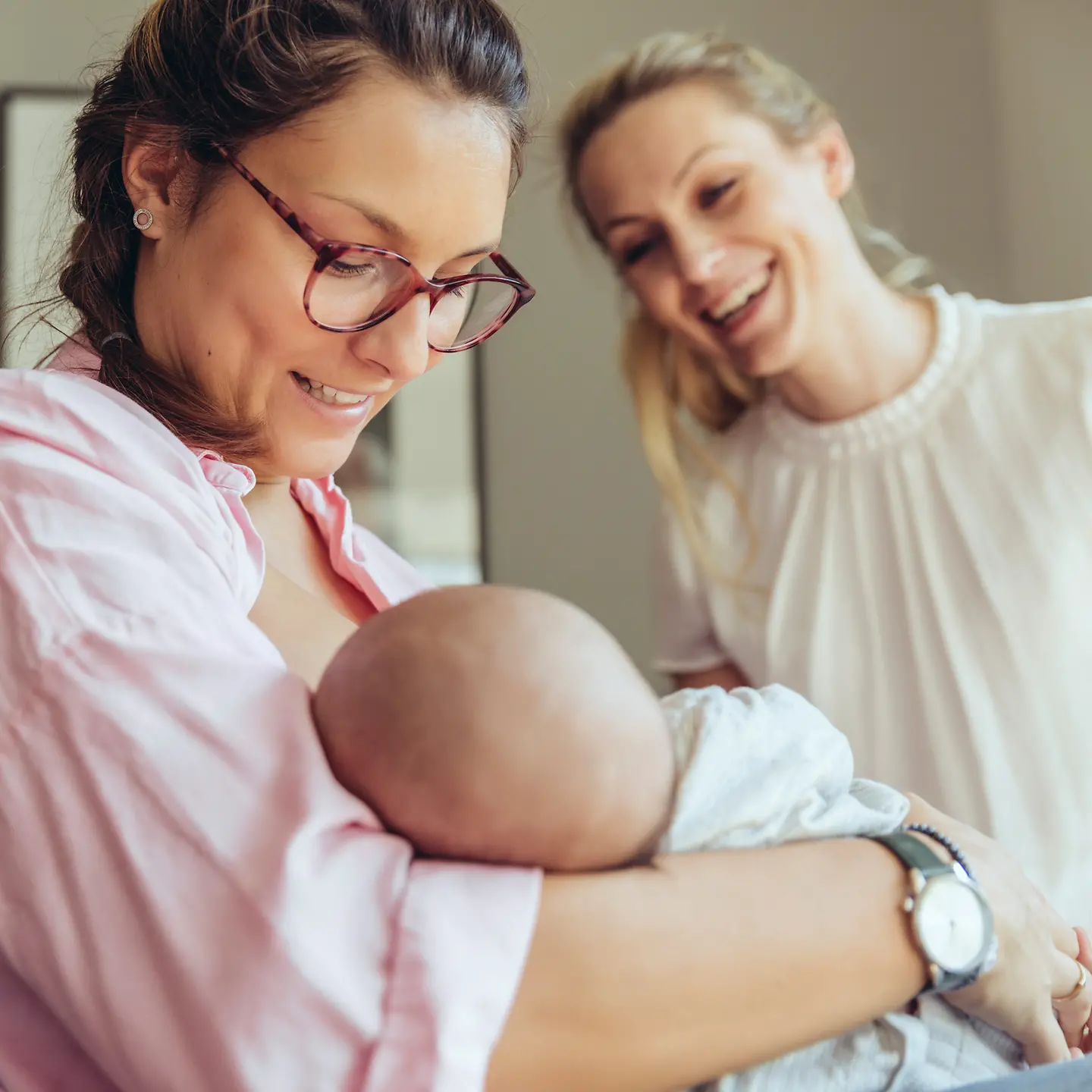 Eine Frau hält ein neugeborenes Baby in ihren Armen.