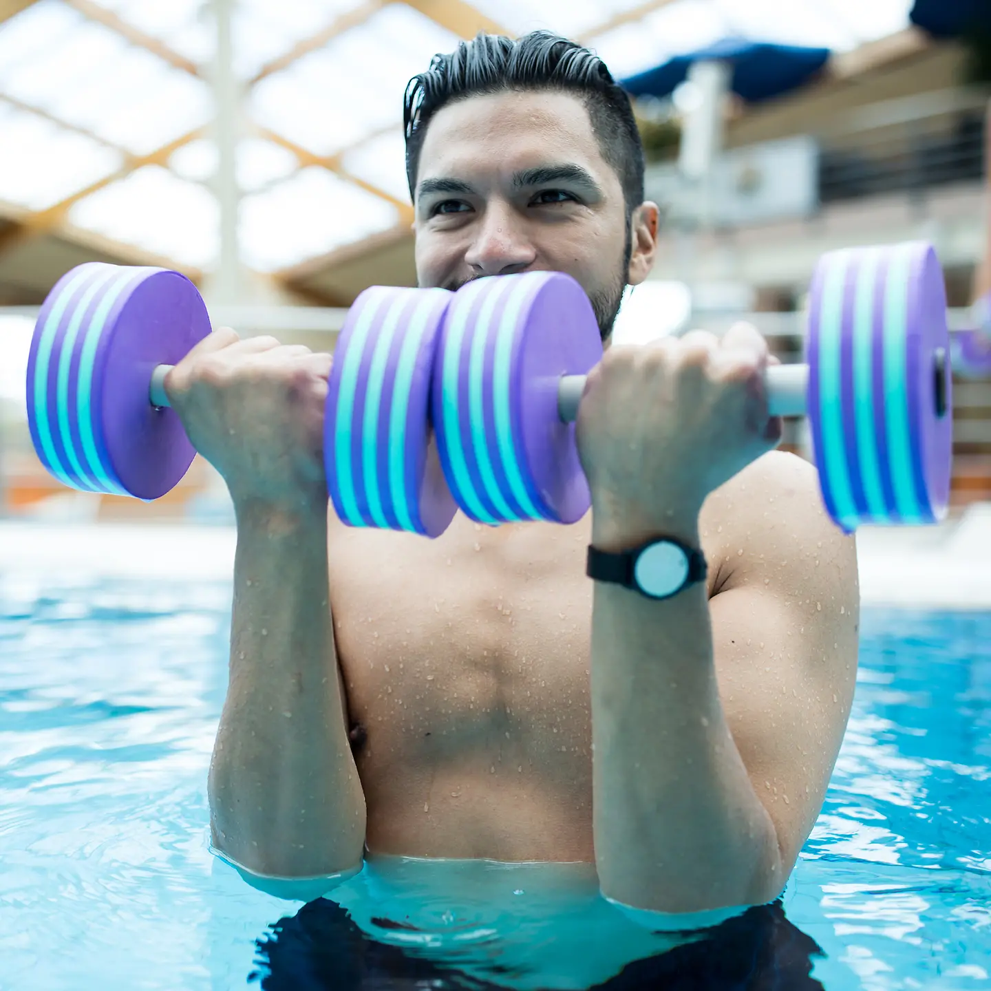 Ein junger Mann trainiert im Wasser mit Aqua-Fitness.